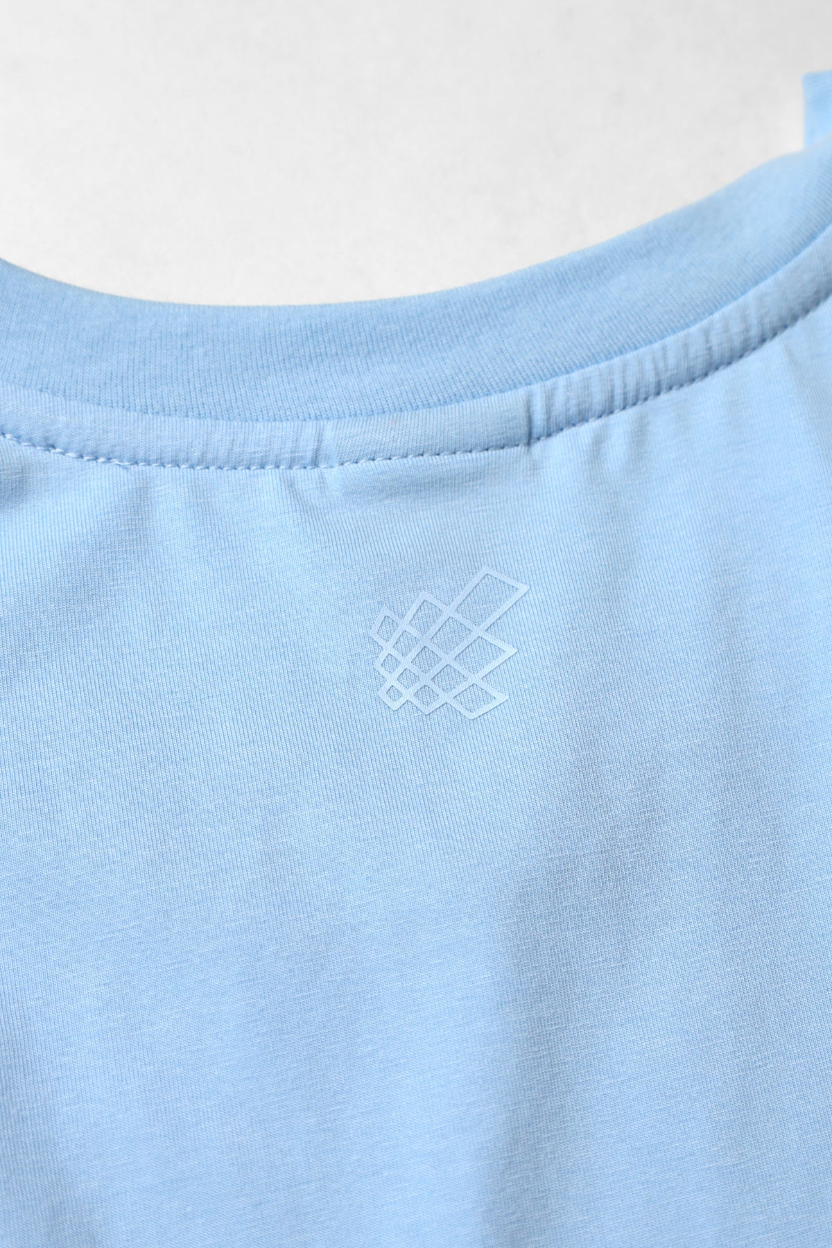 Apollo men’s sleeveless training tee in light blue cotton with a subtle white geometric logo embroidered near the neckline