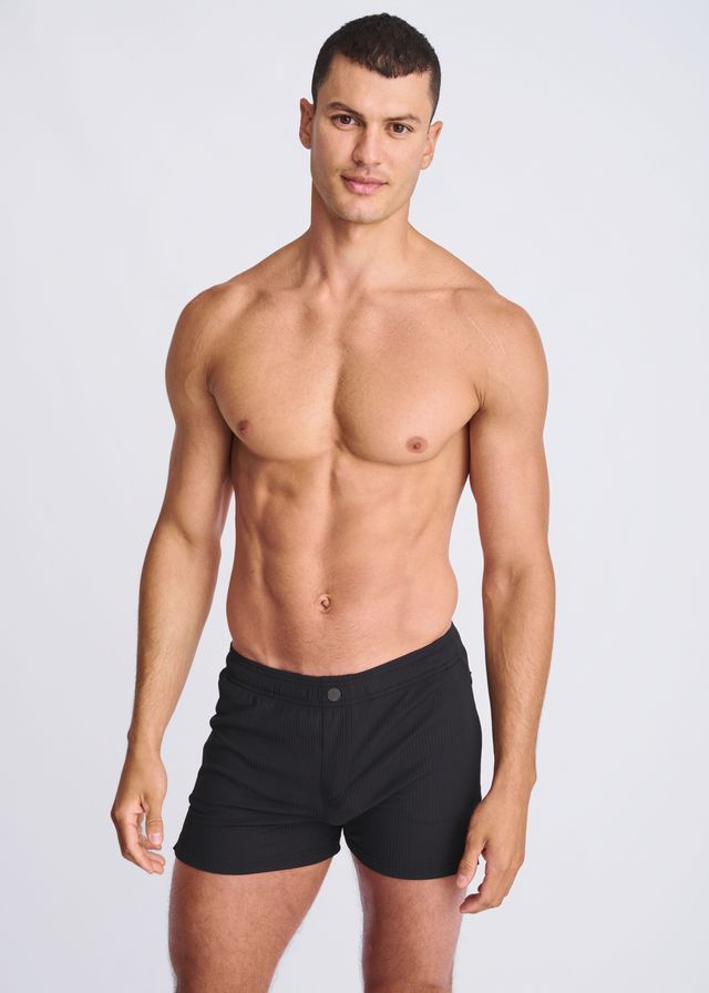 Black seersucker swim shorts with mesh lining featuring sleek minimalist design and single button waistband closure