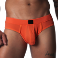 Bright orange athletic jockstrap made of textured honeycomb fabric with a solid black center label on the waistband.