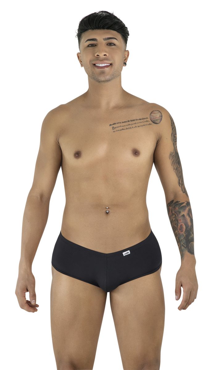 A smiling man poses against a white background, wearing black CandyMan trunks with a V-cut waistband.
