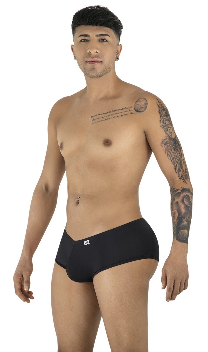 A man with chest and arm tattoos posing in black CandyMan 99943 trunks against a white background.