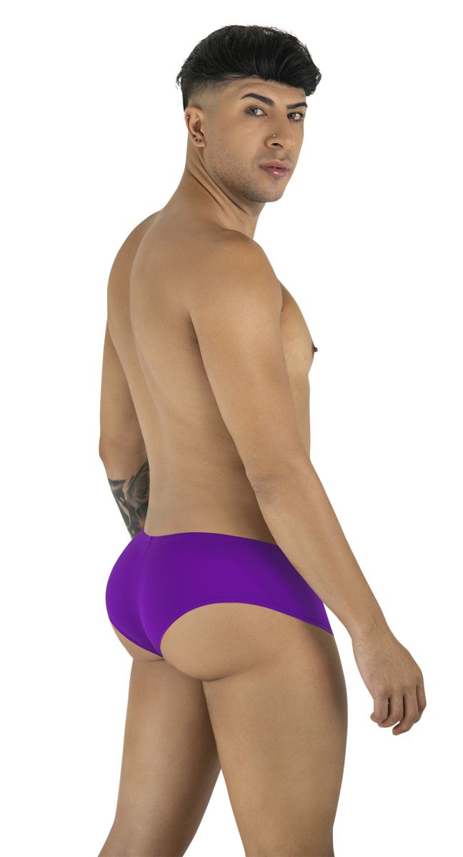 Man wearing orchid-colored CandyMan trunks, standing and looking over his shoulder toward the camera.