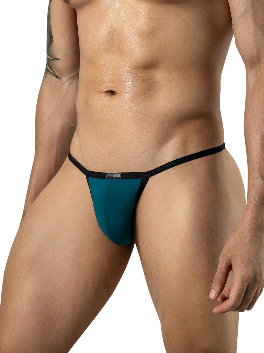 Front view of a person wearing petrol blue minimalist briefs with thin black side straps and a logo tag.
