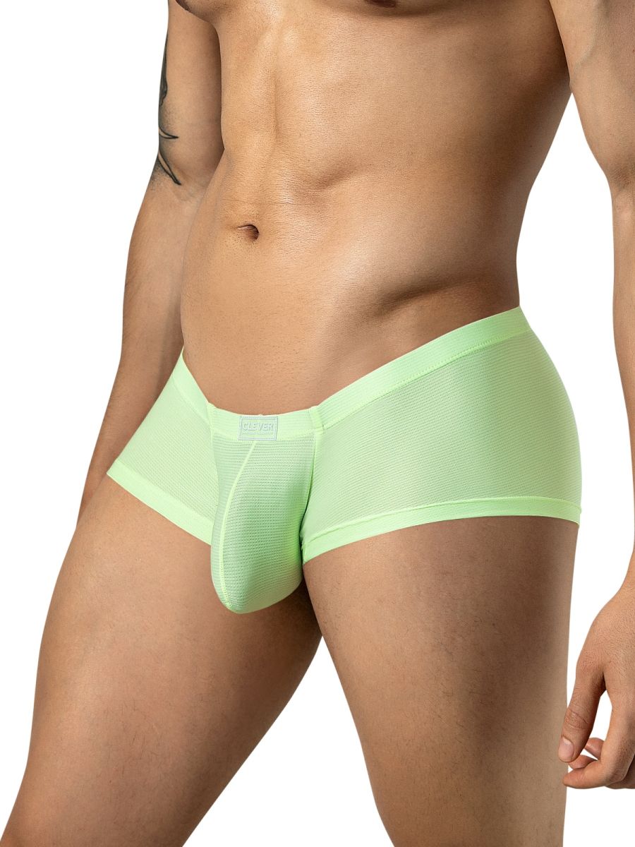 A model wearing neon green mesh trunks with a low-rise fit and a small branded tag on the front.