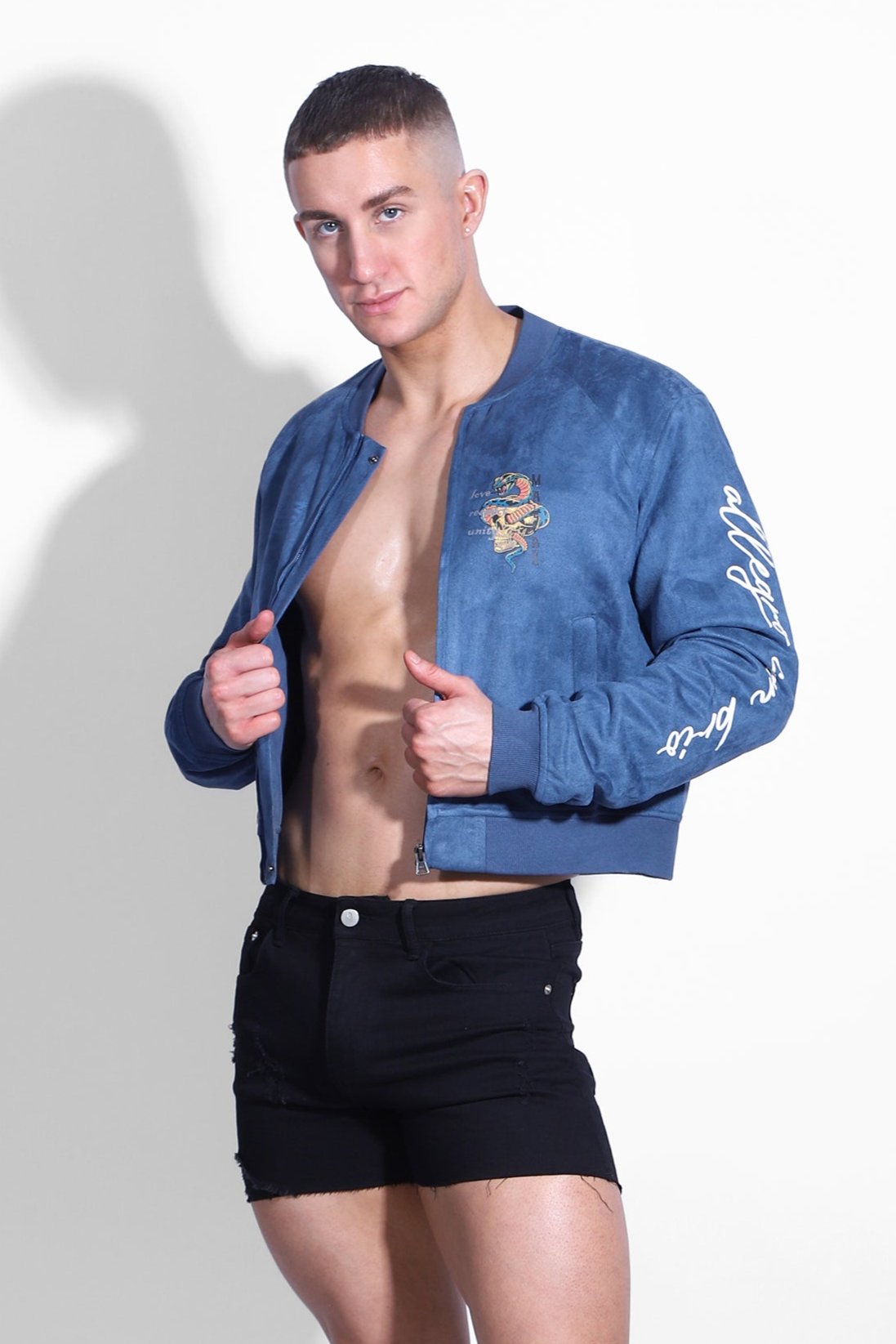 Cropped navy suede bomber jacket featuring embroidered tiger patch and white cursive lettering on the sleeve