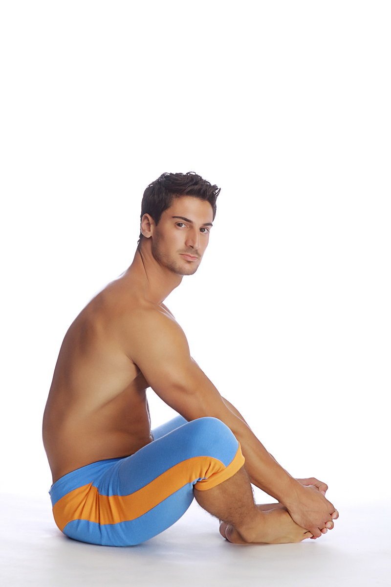 A man wearing cuffed yoga pants in ice blue with orange stripes designed for comfort and flexibility