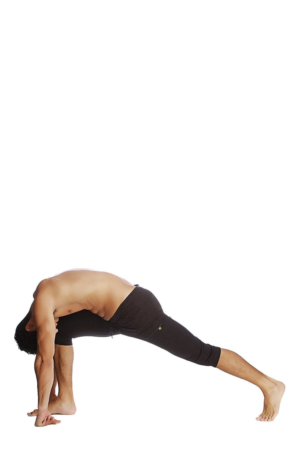 A man wearing solid black cuffed yoga pants in a yoga pose against a white background