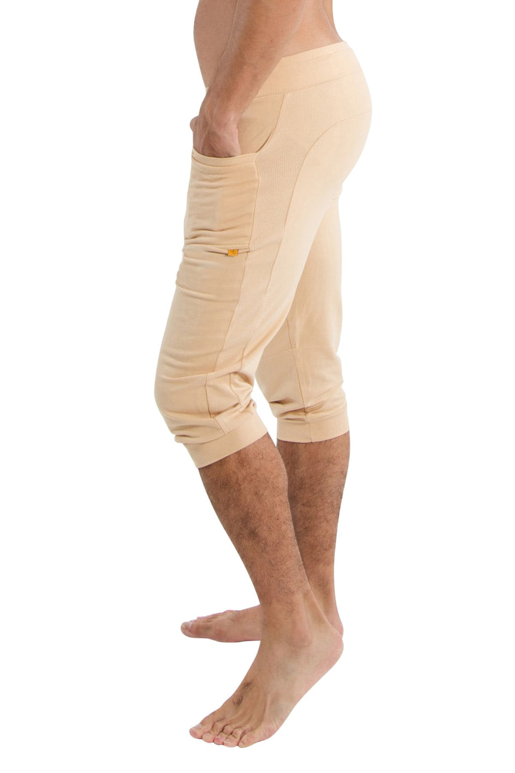 Beige solid sand cuffed yoga pants with side pockets and subtle yellow zipper detail in stretchy fabric
