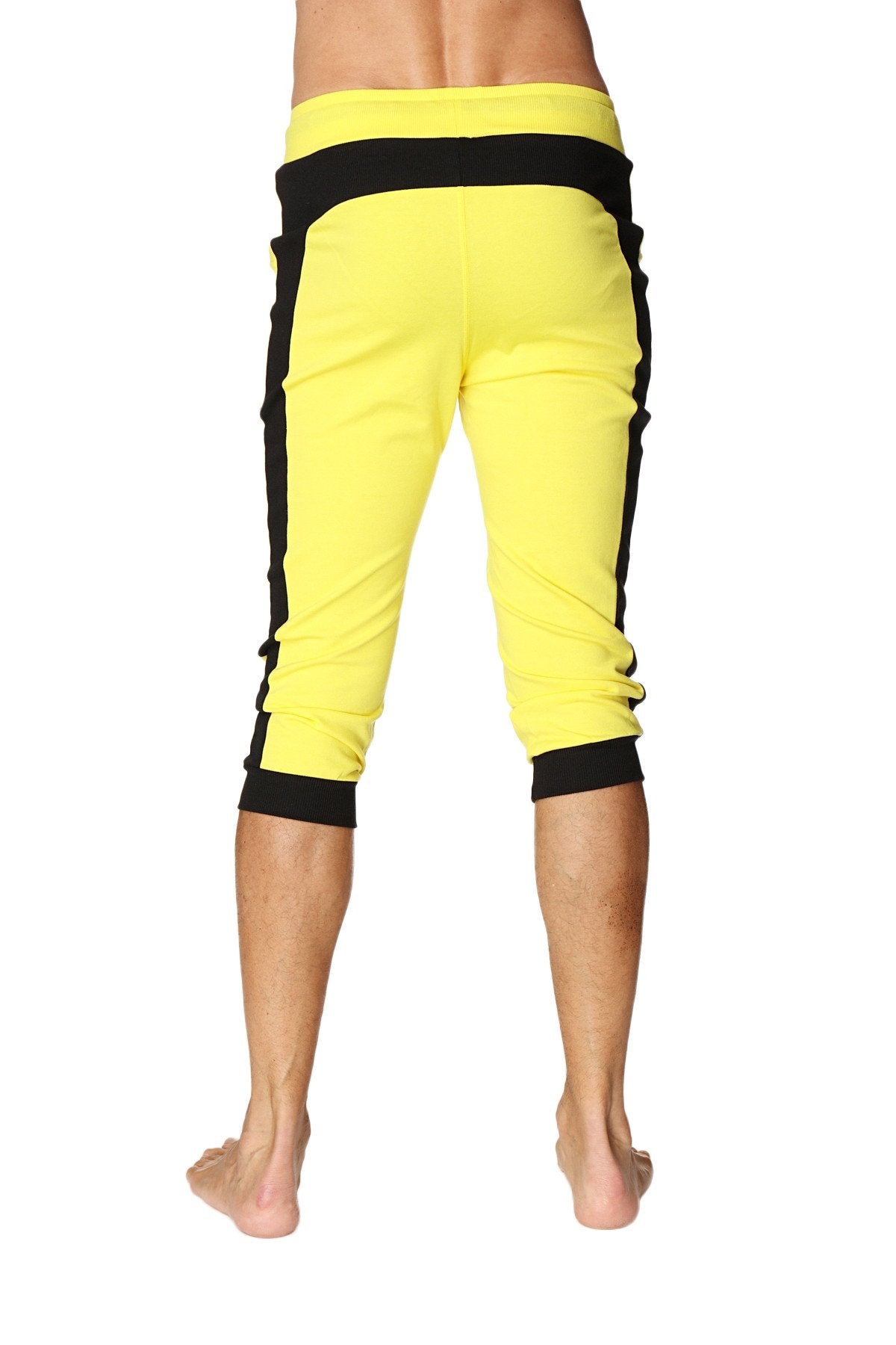 Bright yellow cuffed yoga capri pants with black side stripes and elastic waistband for comfortable wear