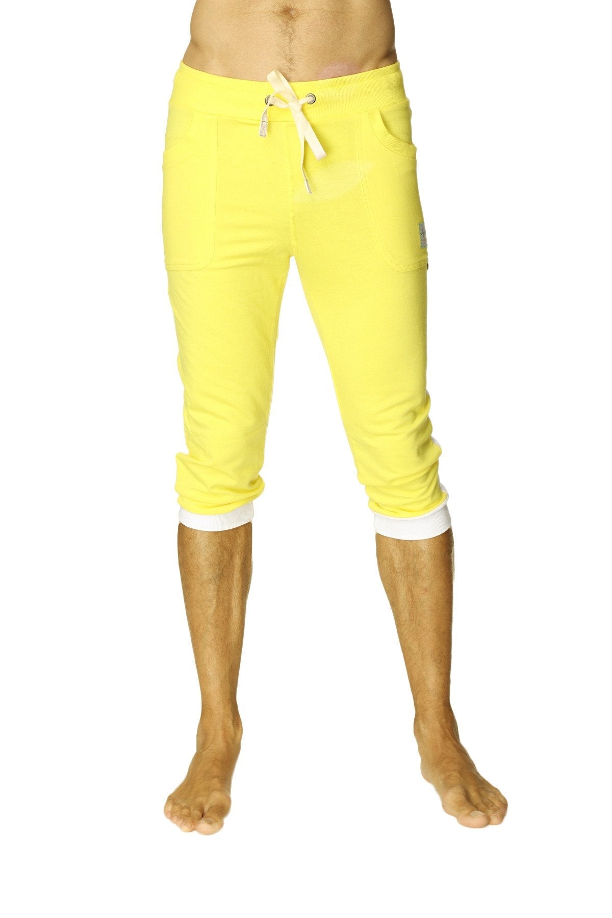 Bright yellow cuffed yoga pants with white drawstring and contrasting white cuffs in capri length for activewear