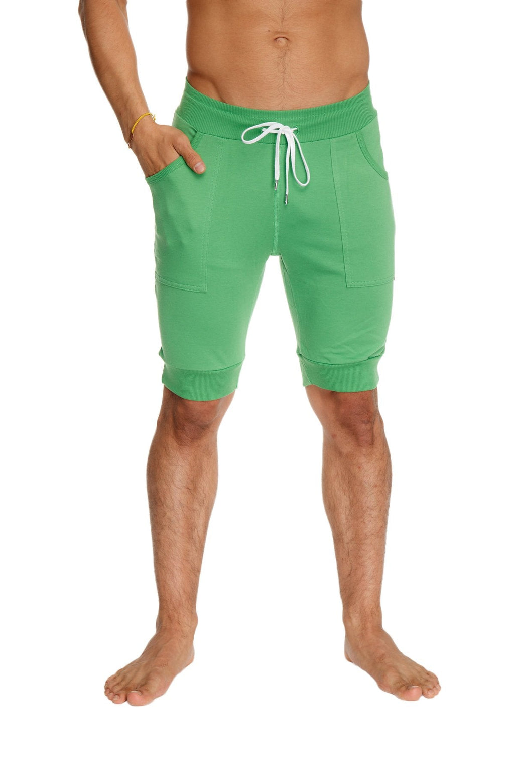 Green cuffed yoga shorts made from bamboo fabric with white drawstring and side pockets for athletic use