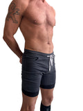 Dark gray cuffed yoga shorts with black trim and white drawstring designed for athletic and casual wear