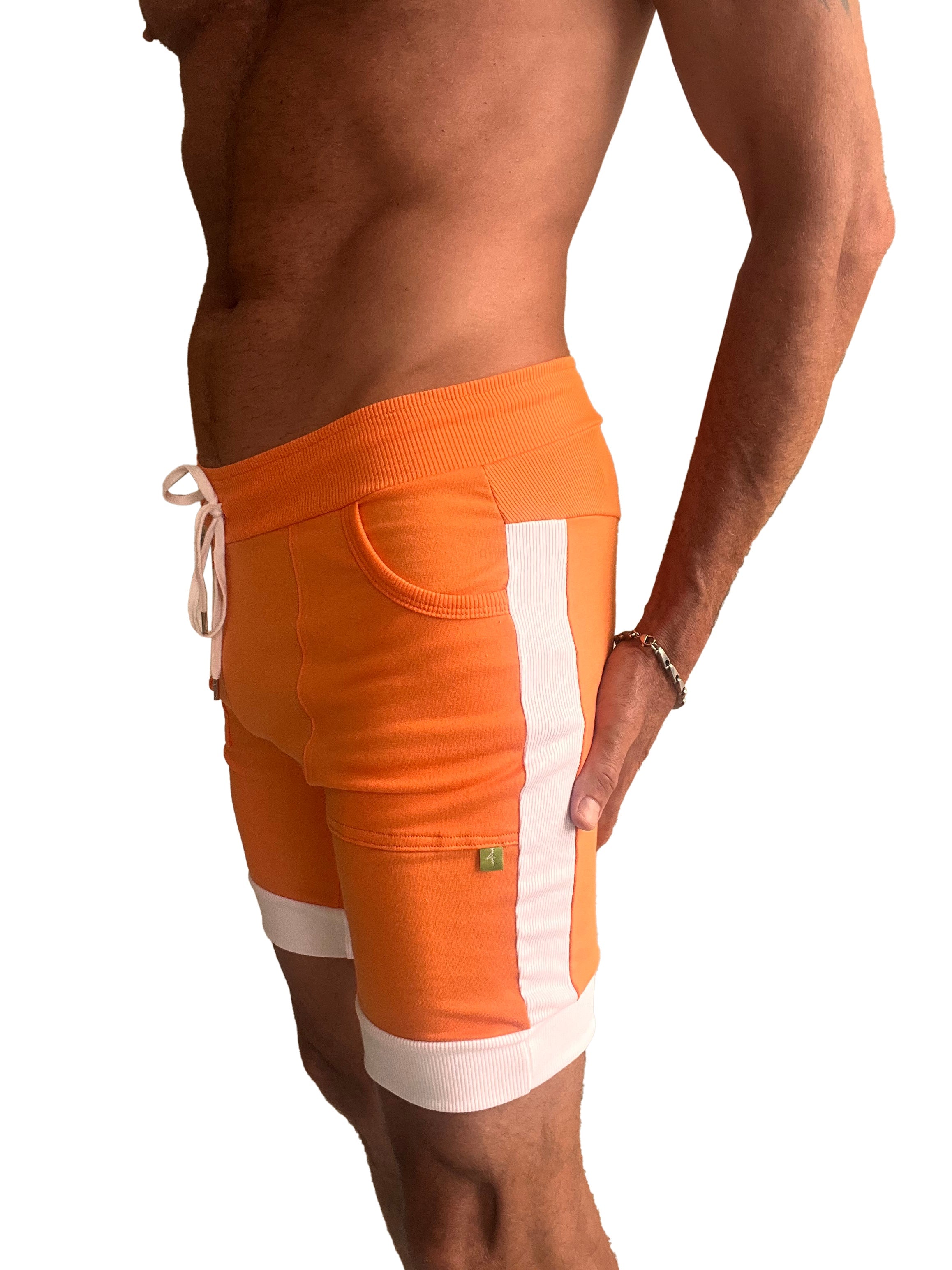 Orange cuffed yoga shorts with white vertical stripes and ribbed cuffs made for athletic use