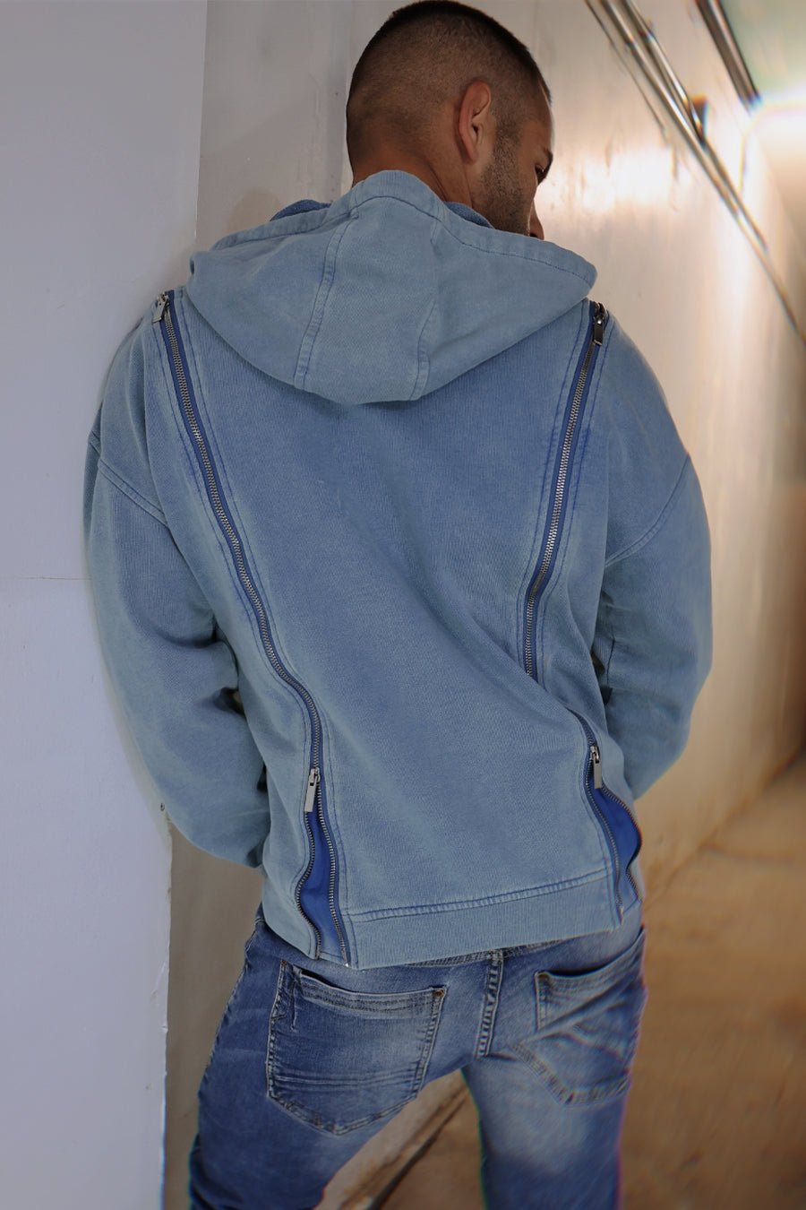Back view of light blue denim darkroom hoodie with distinctive vertical zippers running down the back