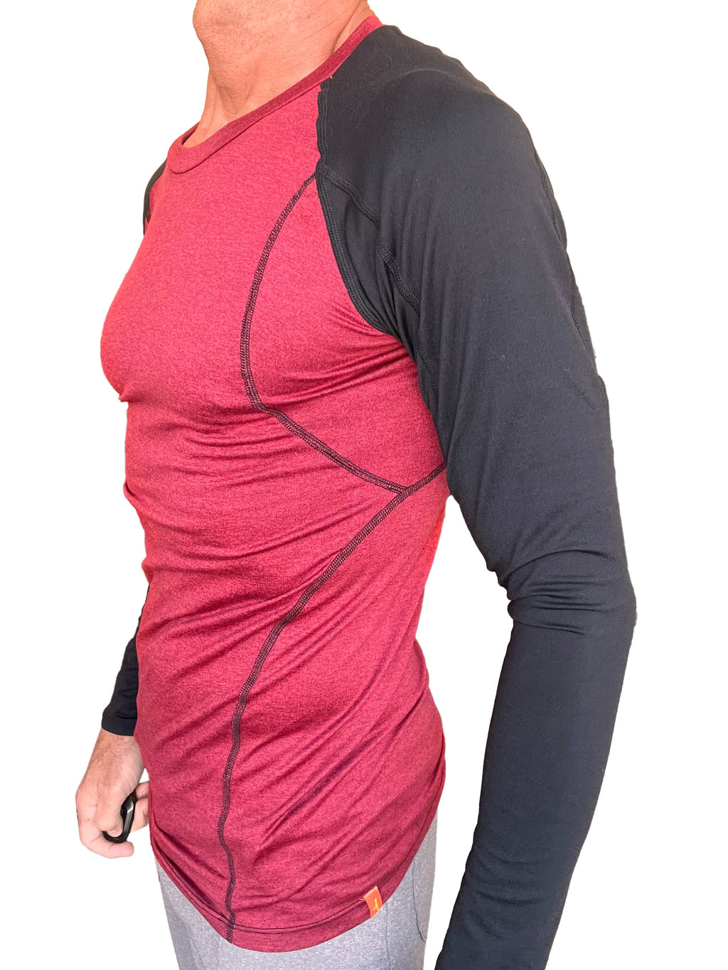 A men’s long-sleeved designer raglan crew-neck tee with a brick red heathered body and black sleeves with stitching