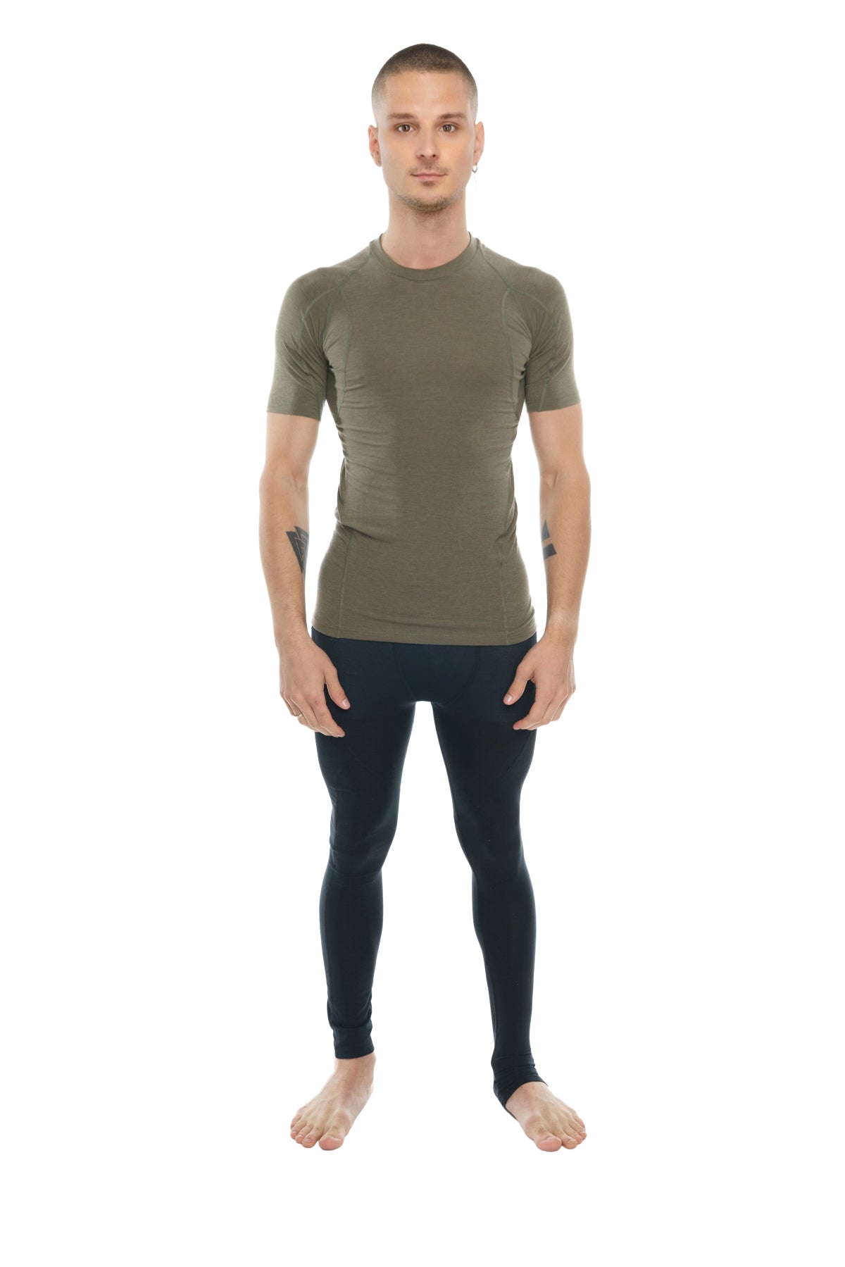 A man wearing an olive green fitted short-sleeved compression shirt paired with black leggings