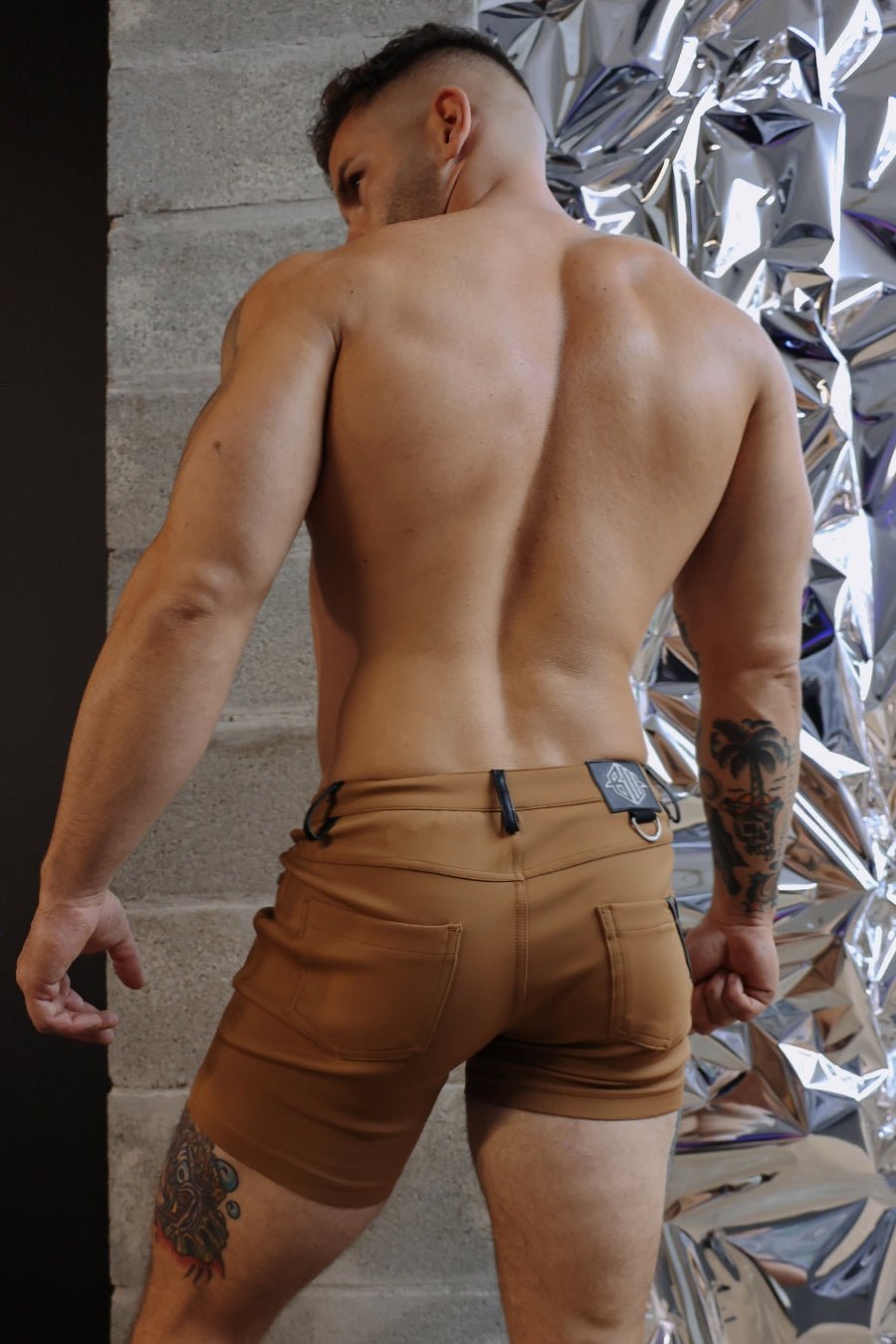 Tan down low cargo shorts with black belt loop and silver-toned metal buckle in dark khaki fabric