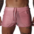 Pink mesh athletic shorts with a drawstring waistband, two side pockets, and a shorter, fitted cut.