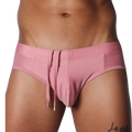 Dusty pink swim brief with a smooth center, side mesh panels, and hanging decorative drawstrings with silver tips.