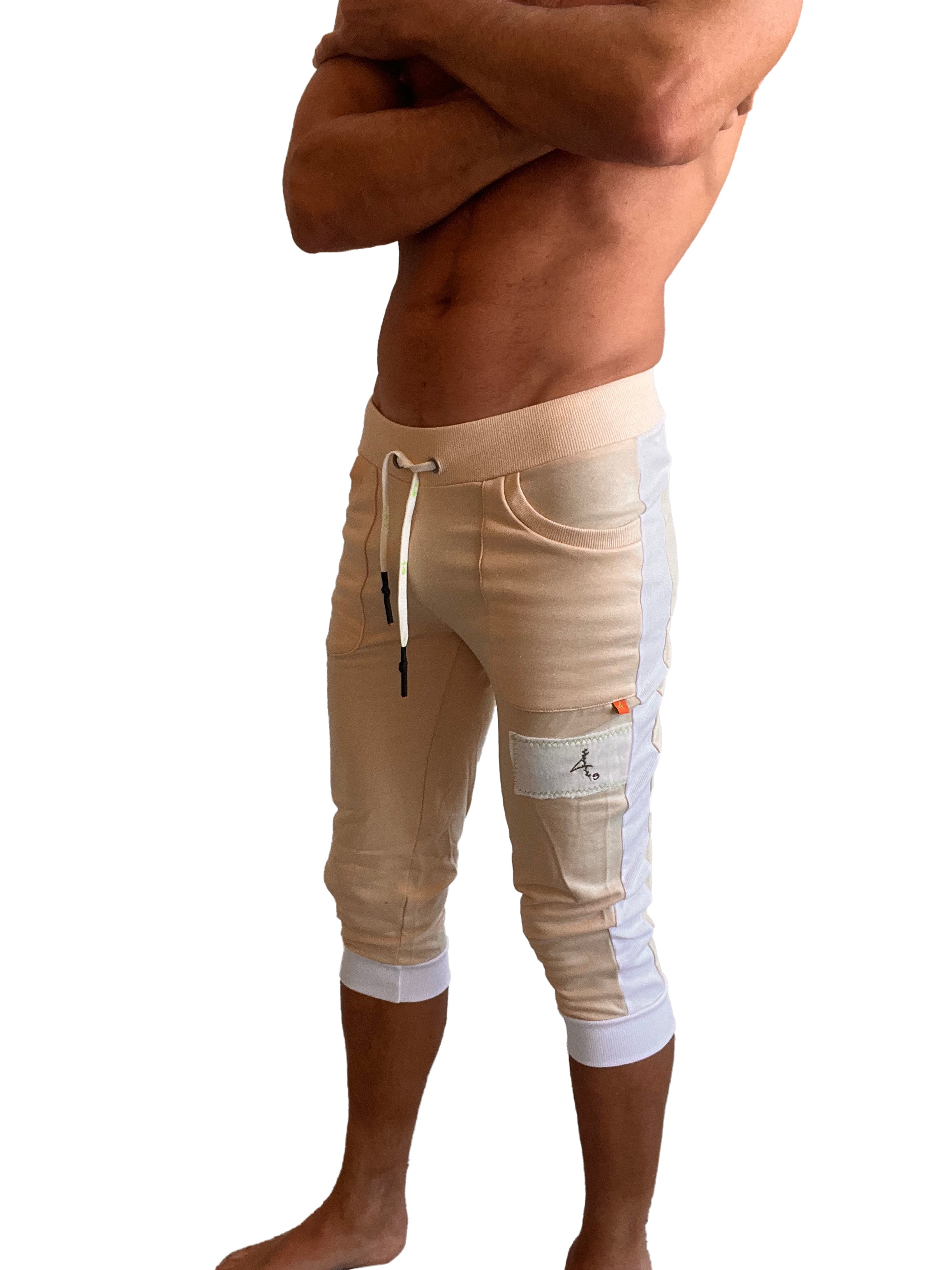 Beige and white edge cuffed yoga pants with drawstring waistband side pockets and embroidered logo patch on thigh
