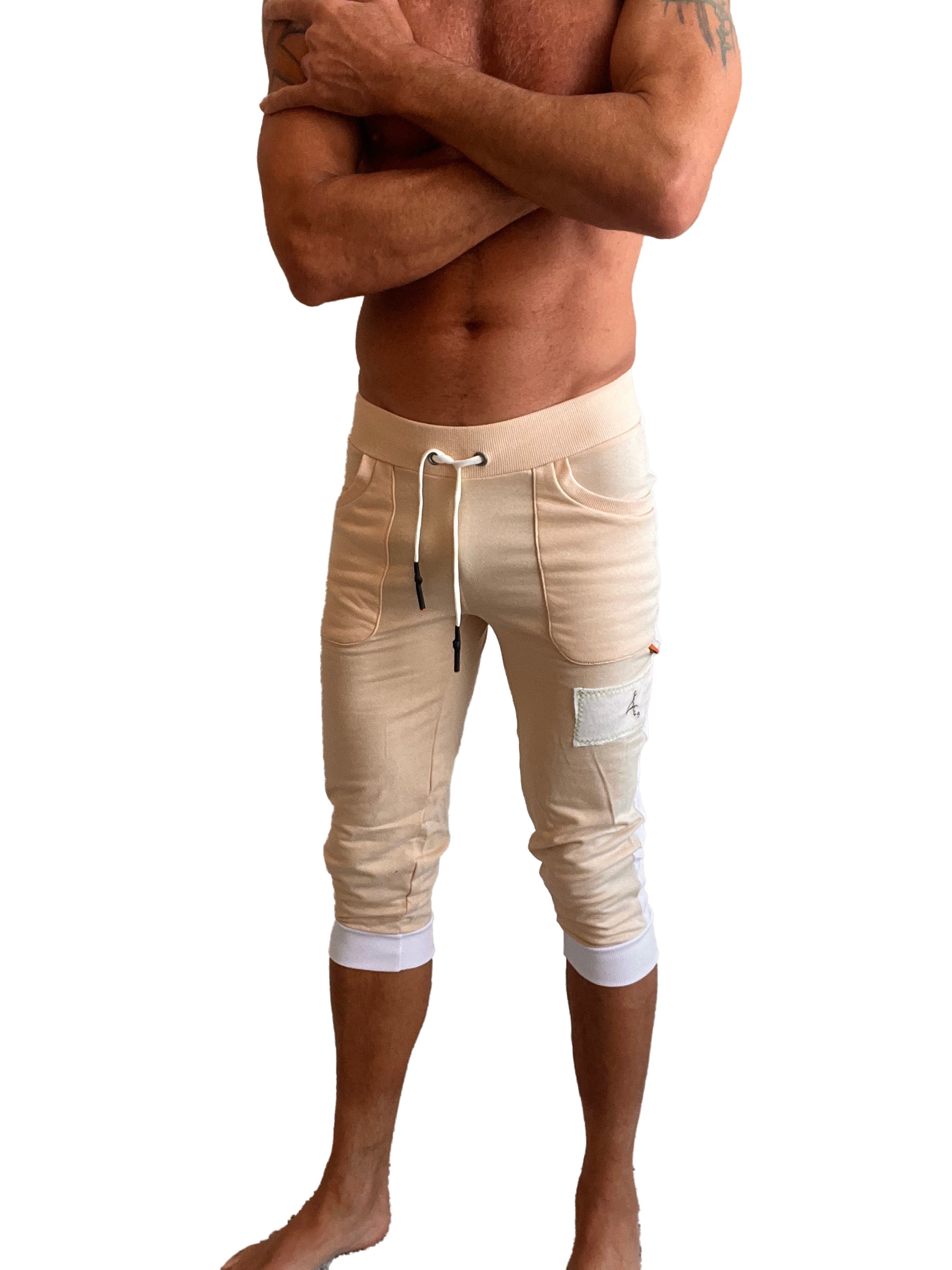 Beige edge cuffed yoga capri pants with white drawstring elastic cuffs and branded patch on the thigh