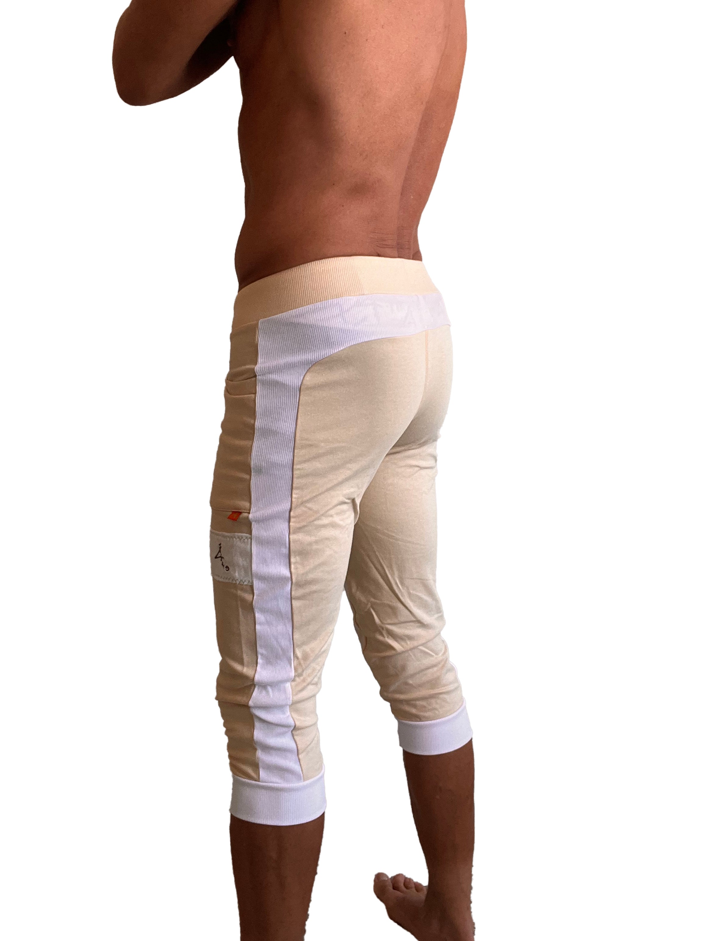 Beige edge cuffed yoga pants with white mesh side panels and elastic cuffs designed for athletic wear