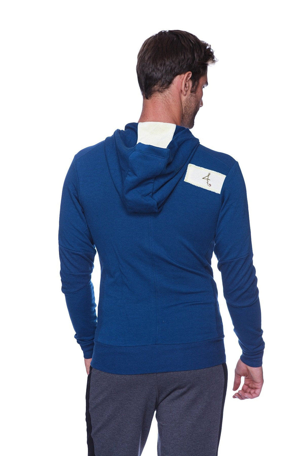 Back view of royal blue edge form-fit crossover yoga track performance hoodie with white collar and rectangular patch