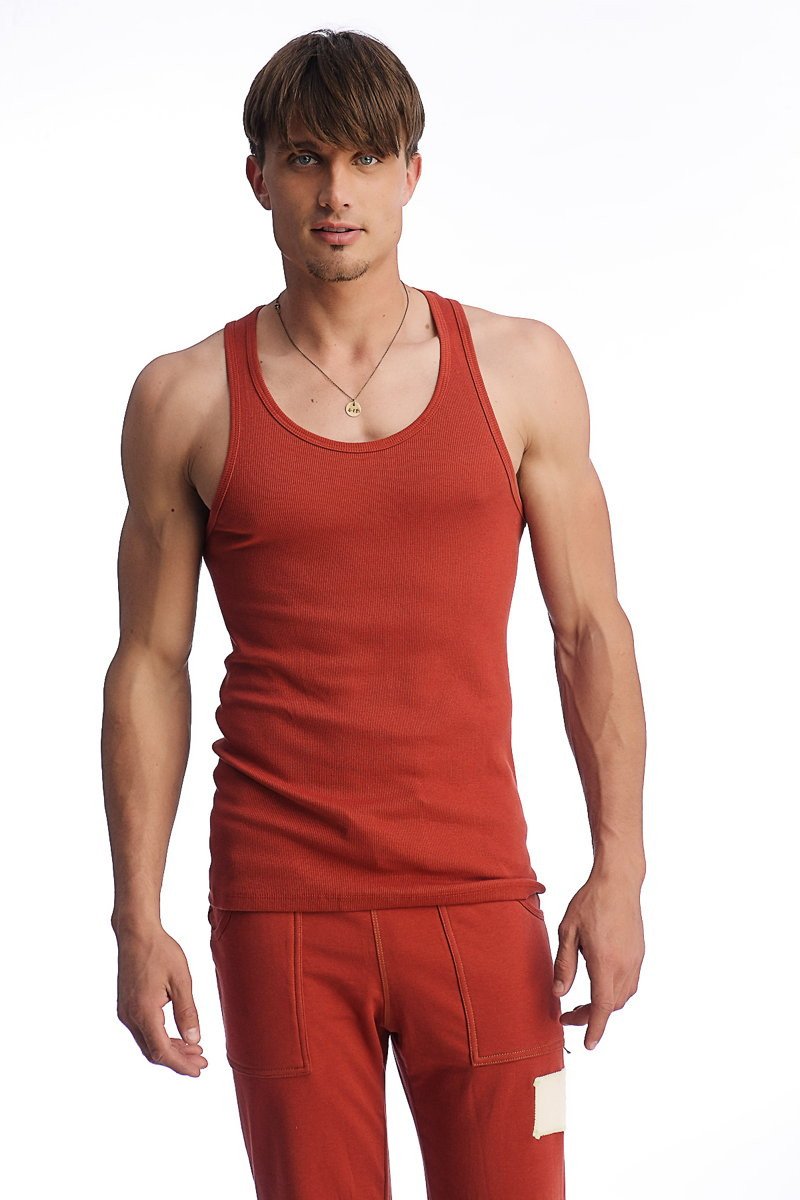 A man wearing a cinnabar edge sustain tank top with ribbed texture and scoop neckline paired with matching pants