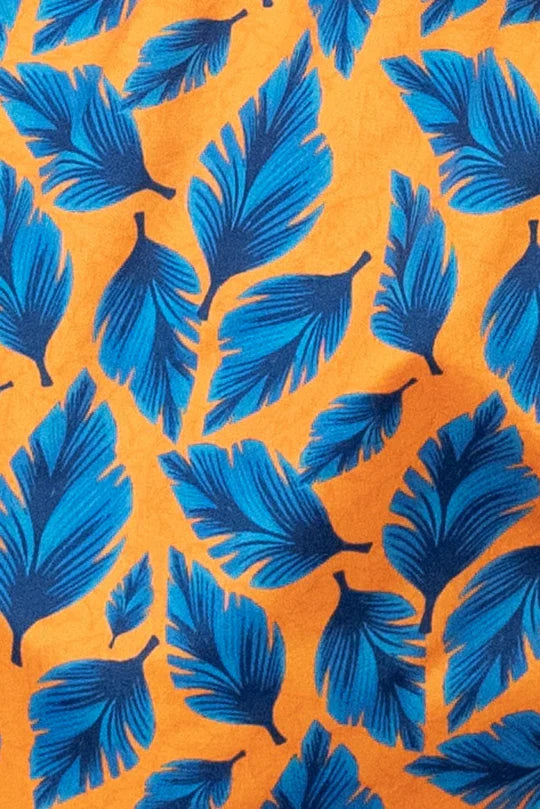Vibrant blue feather print on warm orange fabric of feather print swim short front side material design