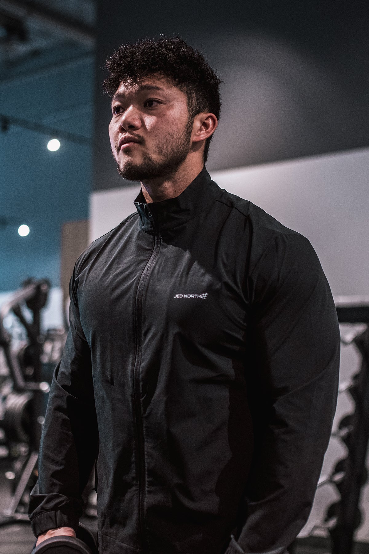 Full-zip training jacket in black with a subtle white logo on the chest ideal for athletic wear