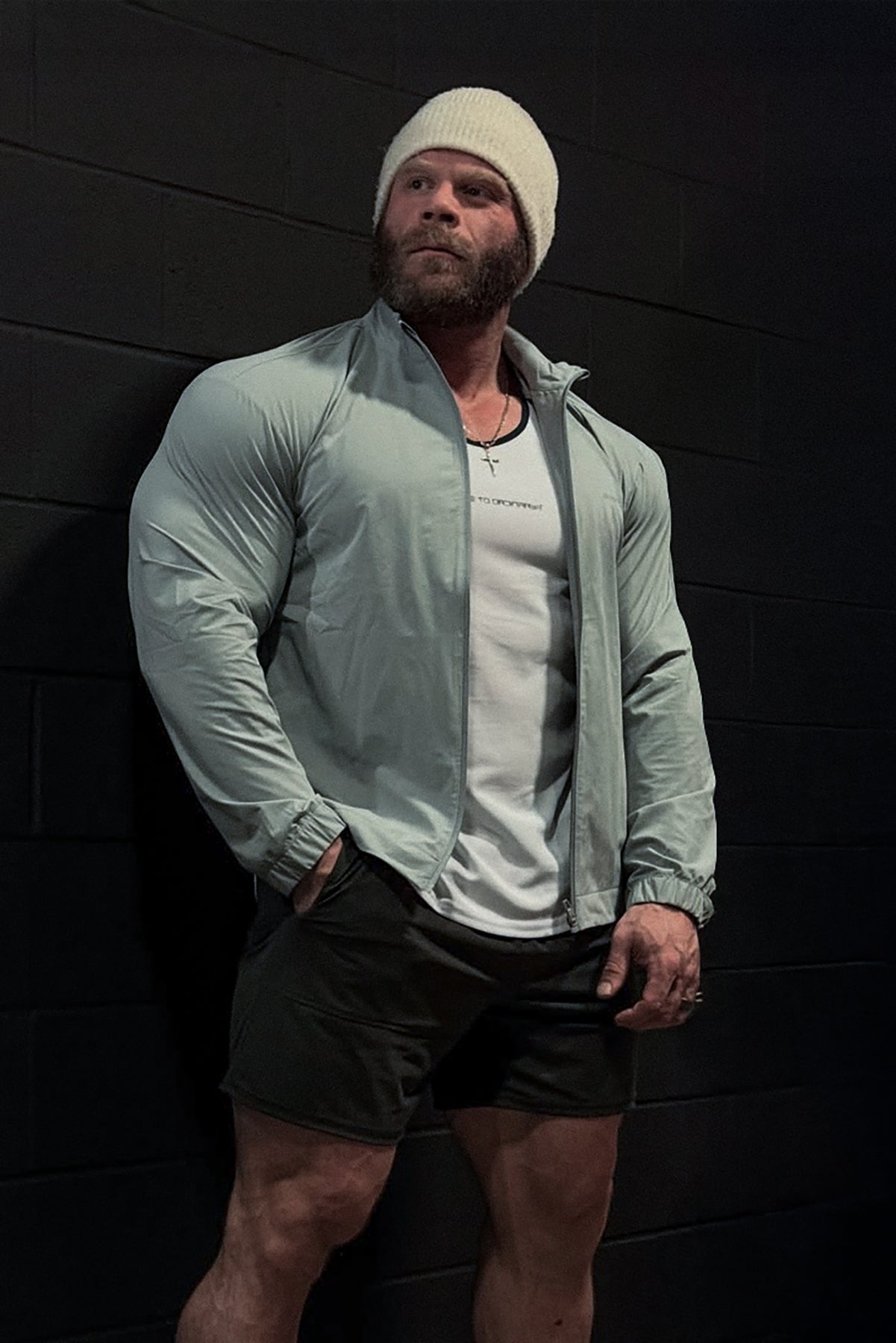 A man wearing a light green full-zip training jacket with elastic cuffs and collar in lightweight fabric