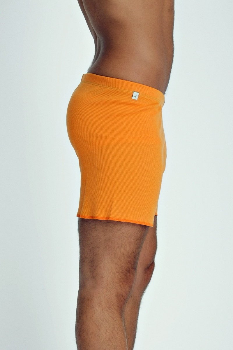Bright orange ribbed men’s fusion yoga shorts with small white logo on waistband designed for active wear