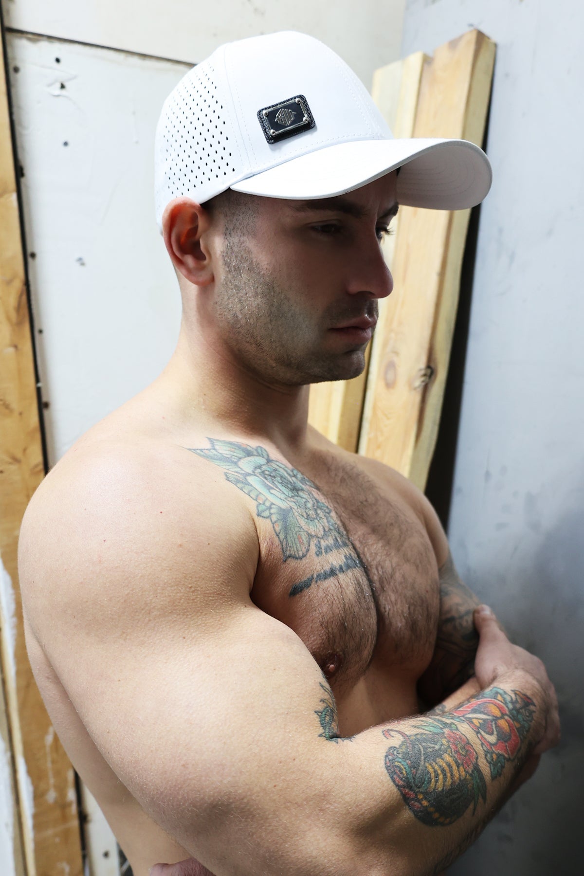 White perforated baseball cap featuring a black rectangular Gymnetixxx logo patch for athletic use