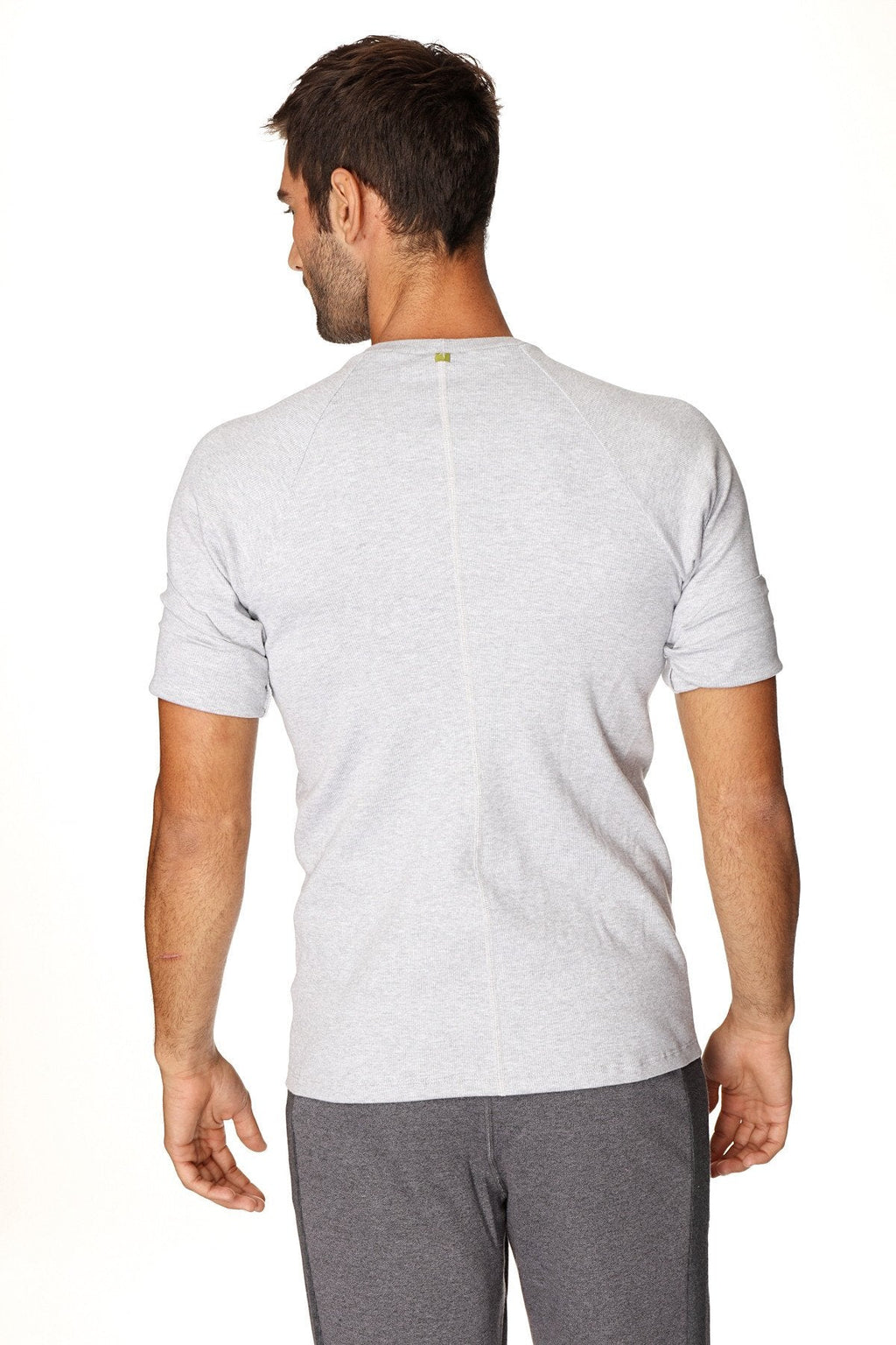 Back view of a heather grey hybrid crew neck raglan tee with a subtle vertical seam and small green logo at neckline