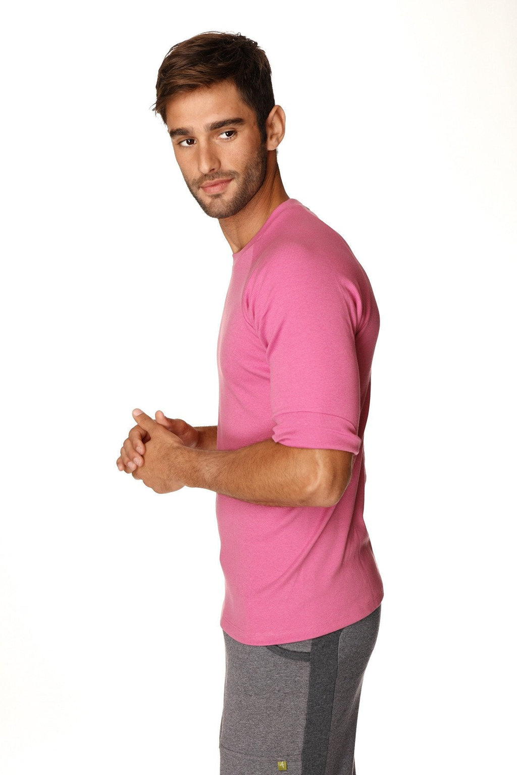 A man wearing a vibrant pink hybrid crew neck raglan tee with short rolled-up sleeves in berry color