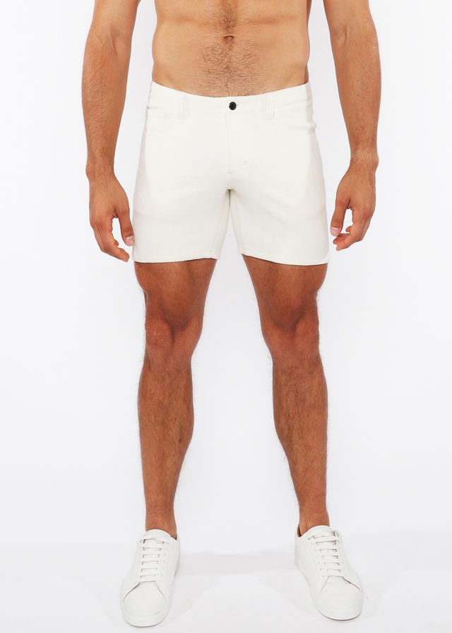 White jacquard stretch knit chino shorts with a sleek form-fitting design and a black button at the waistband