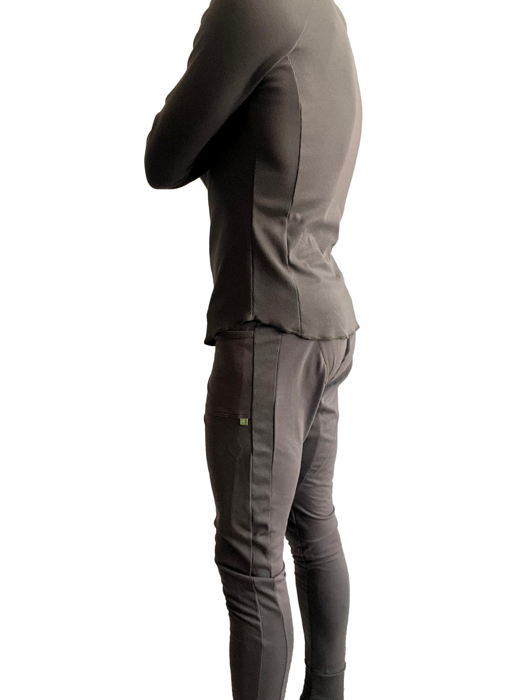 A sleek charcoal-gray two-piece athletic set with fitted long-sleeve top and slim-fit pants with vertical seams