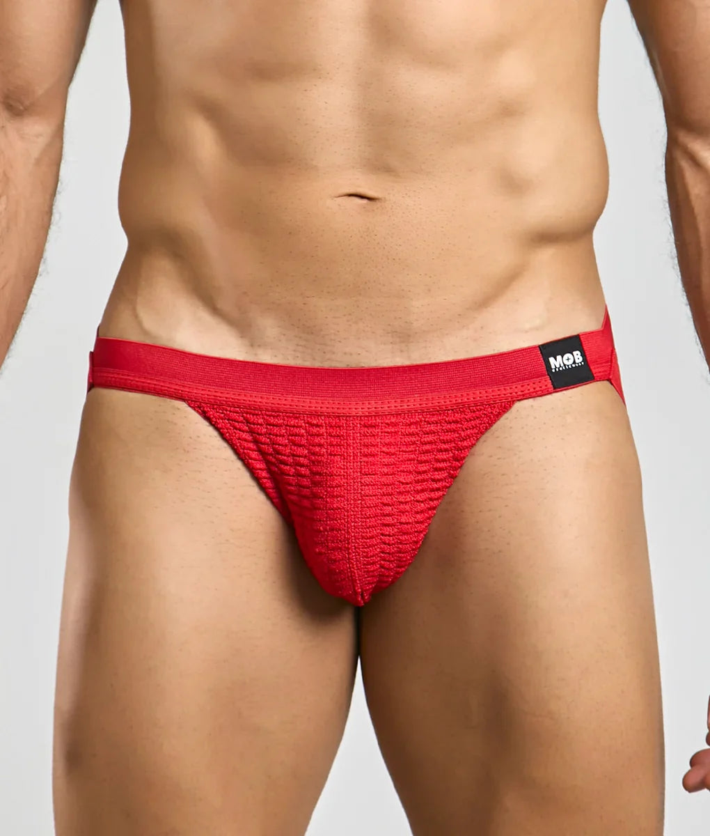 Red textured swim jockstrap briefs with black mob brand tag on waistband designed for swimwear use