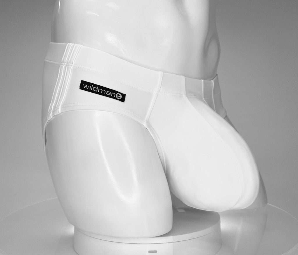 White WildmanT swim brief with contoured pouch on a mannequin, featuring triple-stripe side detail and logo patch.