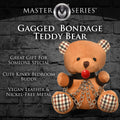 A tan master series bondage teddy bear with plaid ears and feet, red ball gag, black leather restraints, and silver chains