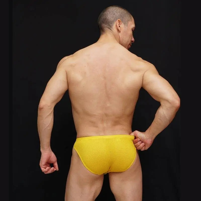 Men's yellow mesh bikini underwear by Arroyman featuring a snug fit and textured fabric shown from the back on a model.