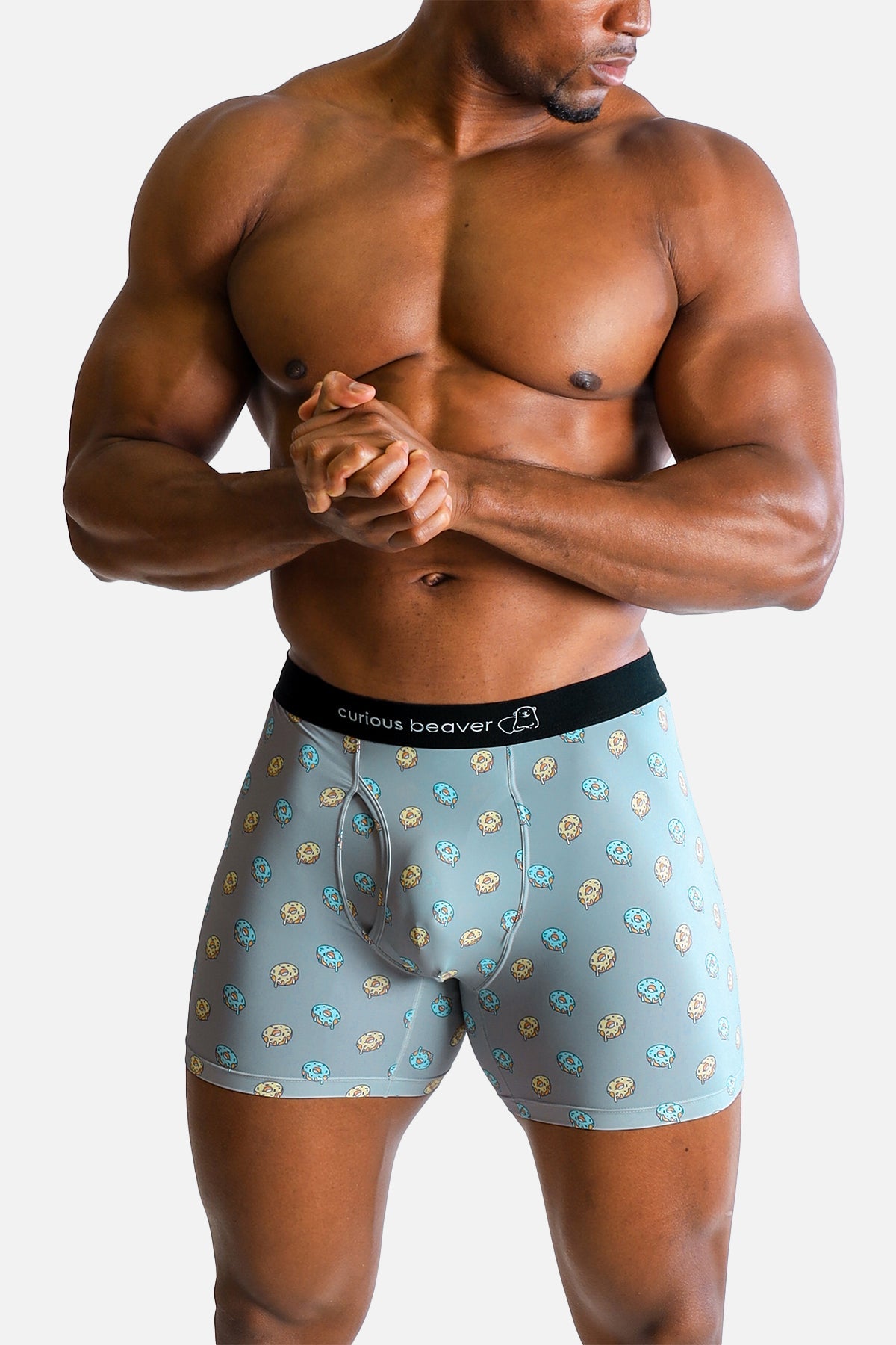 Men’s light blue boxer briefs with yellow and teal donut pattern and black curious beaver branded waistband
