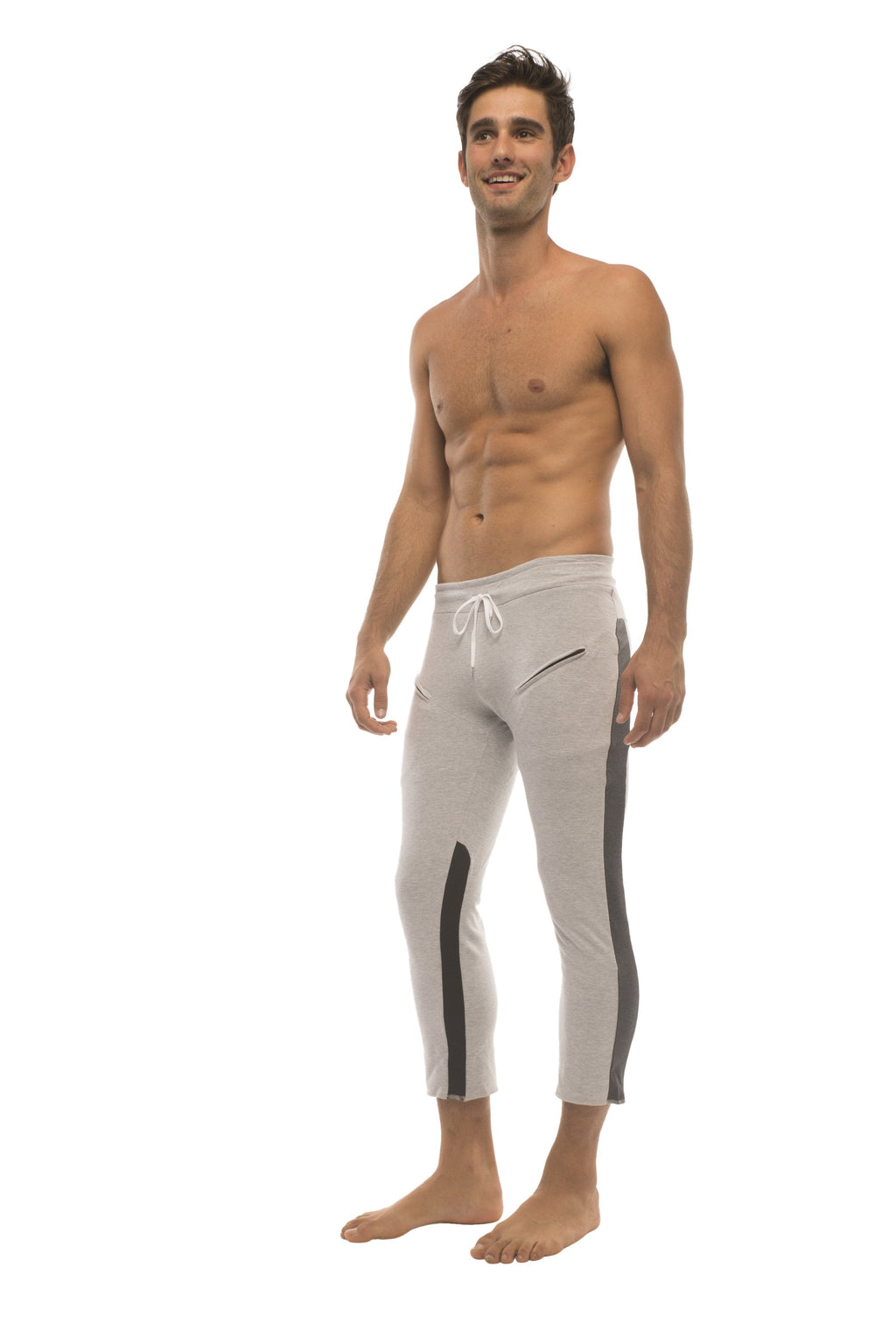 Mens grey capri yoga pants with black side stripes and white drawstring waistband featuring 4 of 5 zipper pockets