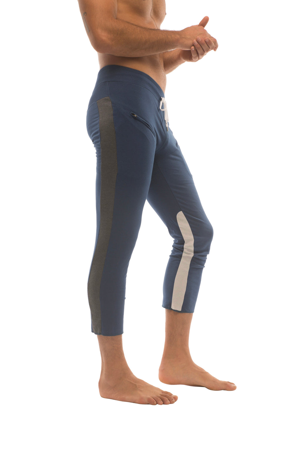 Mens navy blue athletic capri yoga pants with dark green and white side stripes and zipper pockets for active wear