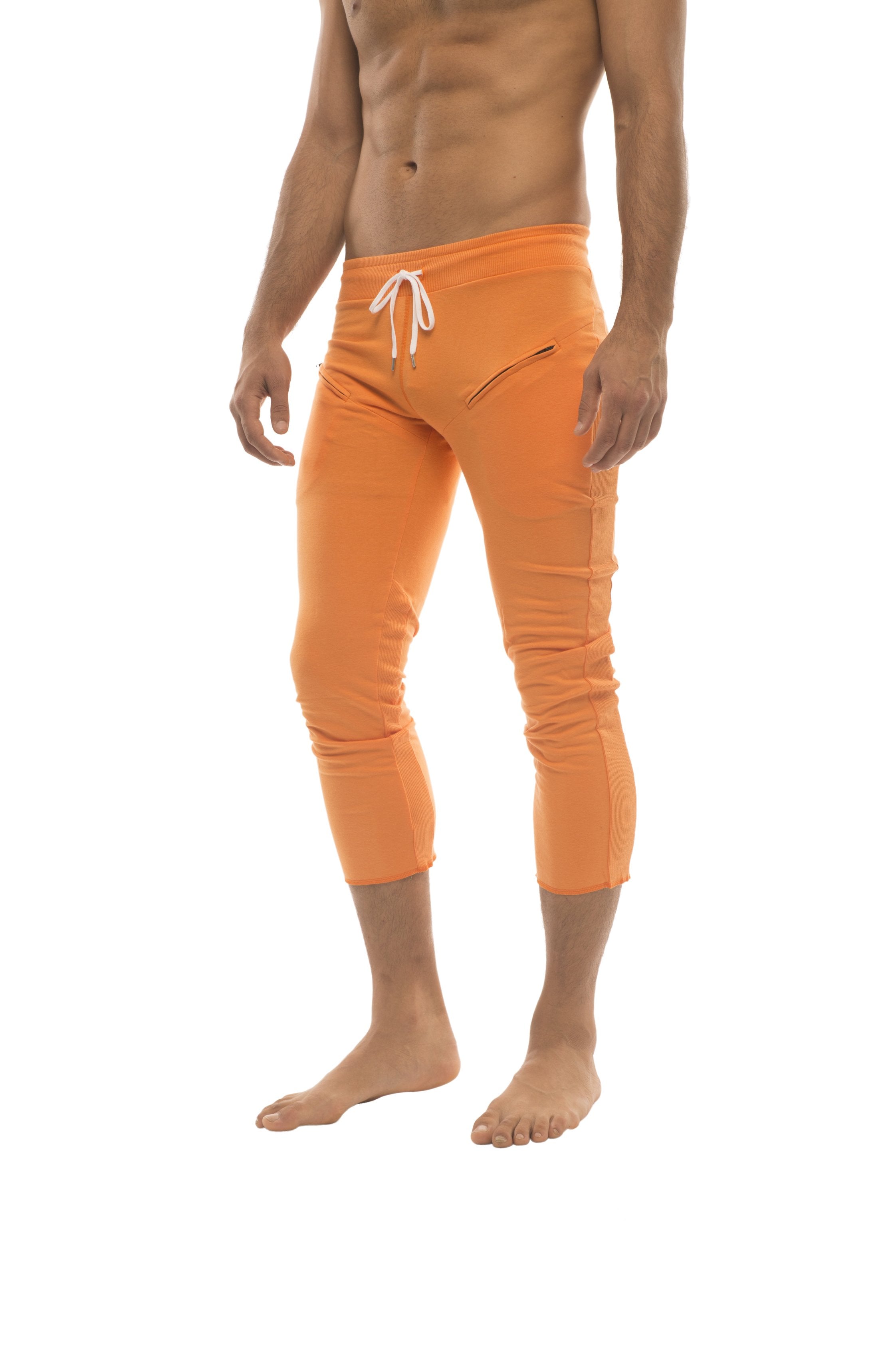 Mens solid orange 4/5 zipper pocket capri yoga pants with white drawstring waistband and subtle side pockets
