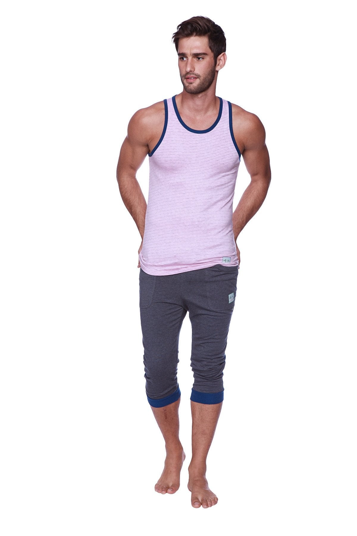 A man wearing mens cuffed yoga pants charcoal with royal blue cuffs and a light pink striped tank top