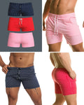 Three pairs of short, vertically striped swim trunks in navy, red, and pink with white drawstring waistbands.