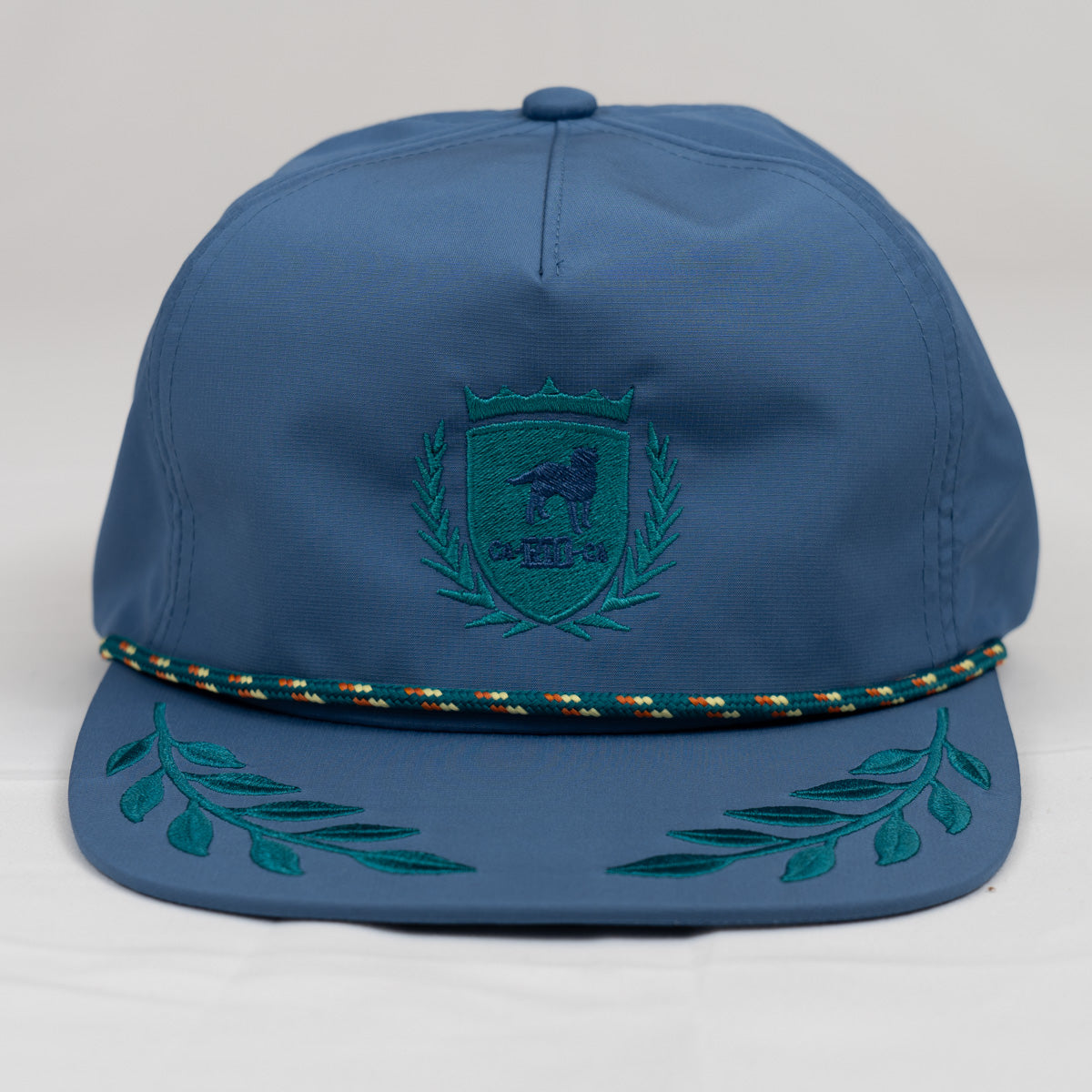 GORRA CON BAJADA A PRESIÓN Y CUERDA CON LOGOTIPO DE CA-RIO-CA Y ESTILO HOJA DE LAUREL SIN ESTRUCTURA