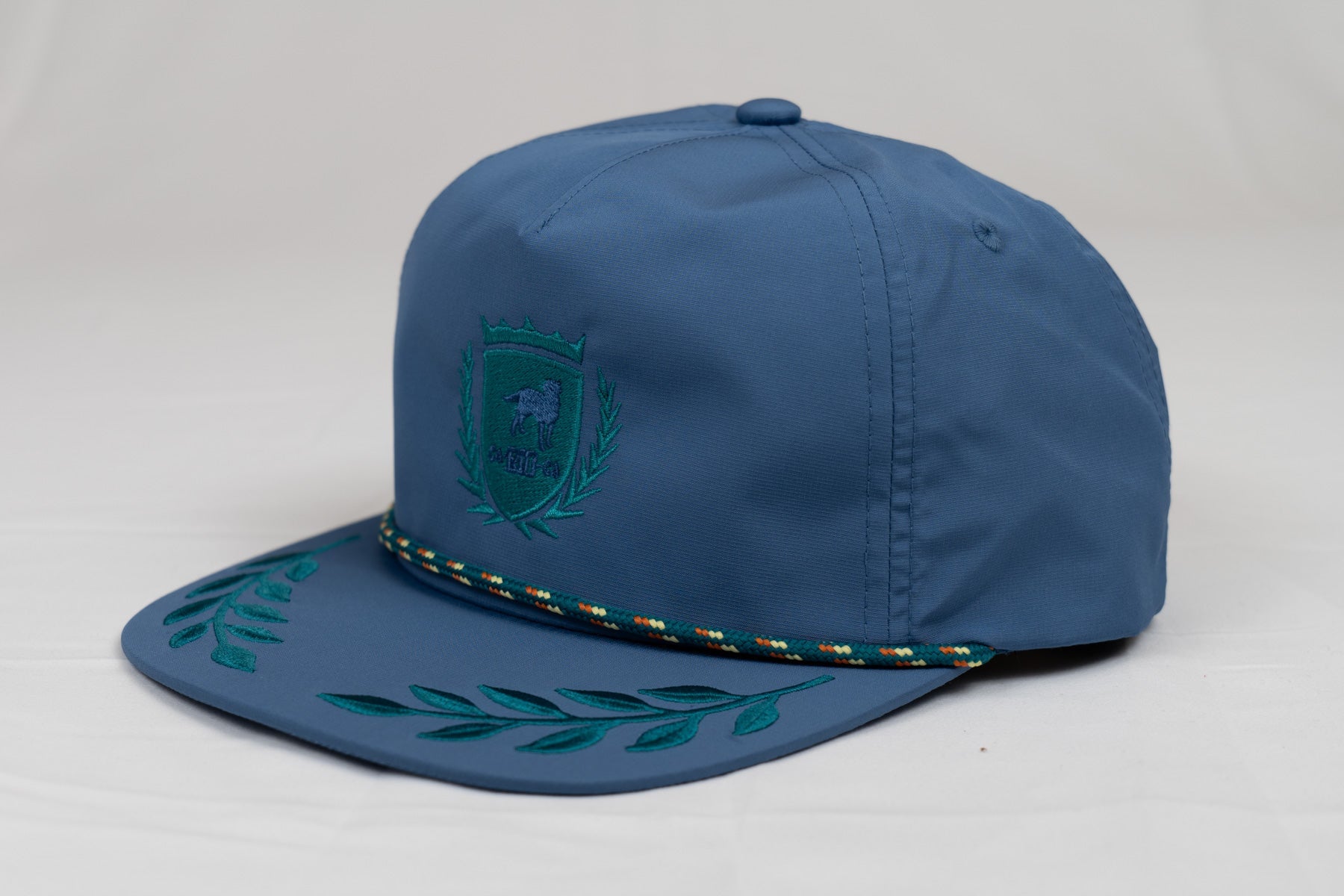 GORRA CON BAJADA A PRESIÓN Y CUERDA CON LOGOTIPO DE CA-RIO-CA Y ESTILO HOJA DE LAUREL SIN ESTRUCTURA