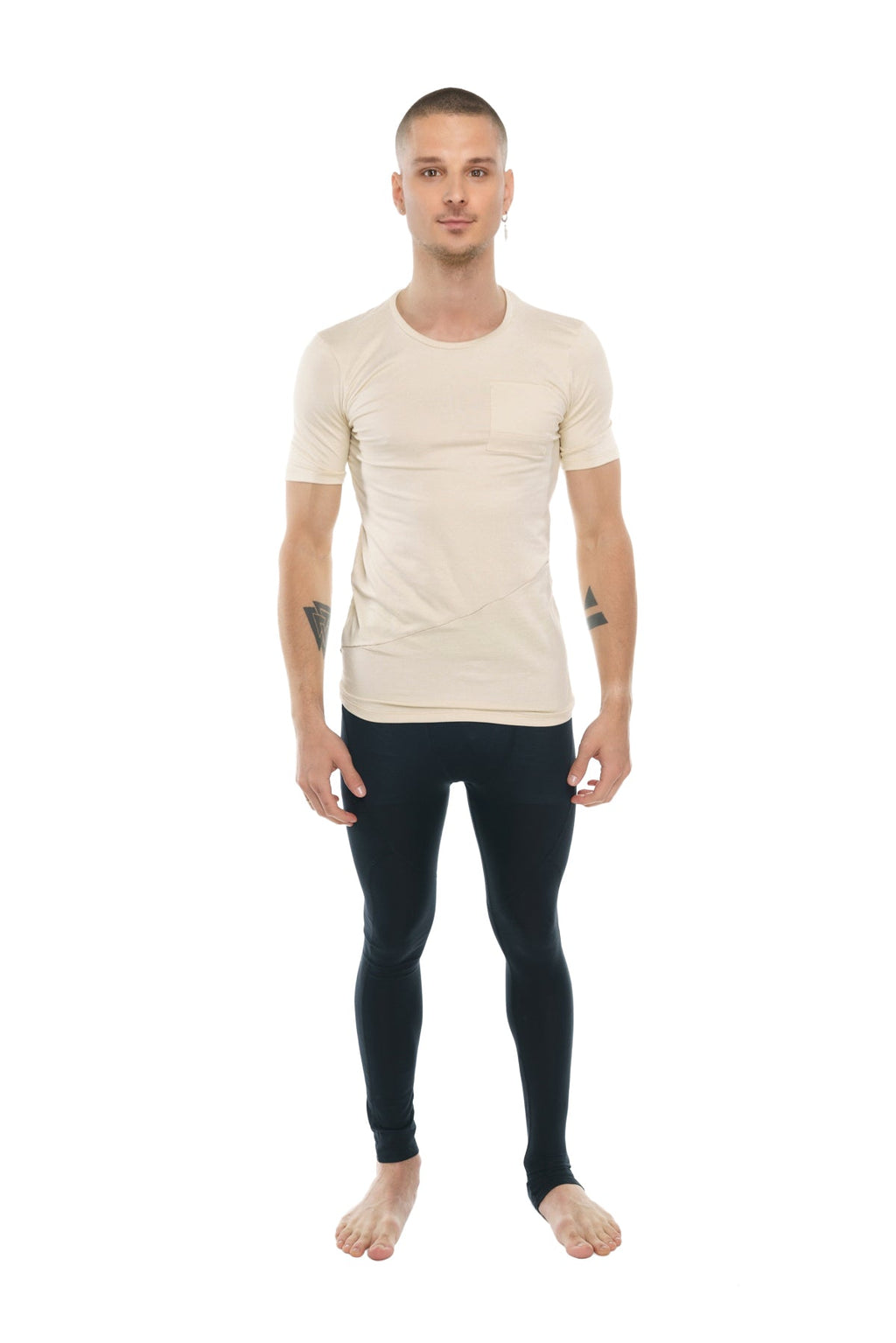 A man wearing a beige fitted perfect pocket crew-neck tee with short sleeves paired with black leggings